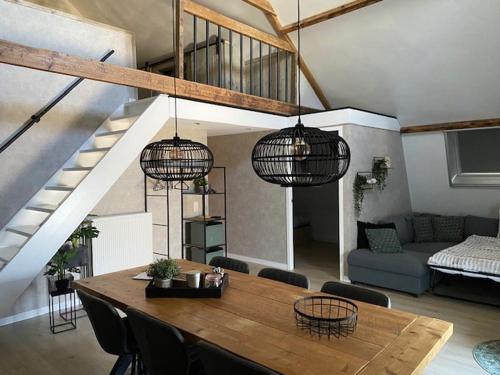 Gastenverblijf Rodenburg في Streefkerk: غرفة معيشة مع طاولة وكراسي خشبية