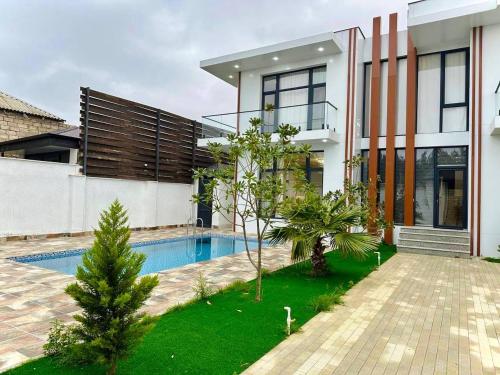 uma casa com uma piscina em frente em Villa Buzovna1 em Buzovna