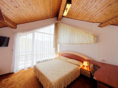 a bedroom with a bed and a large window at Hotel Oasis in Braşov