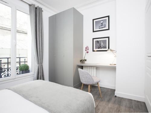 une chambre avec un lit, un bureau et une fenêtre dans l'établissement LivinParis - Luxury 2 Bedrooms Grands-Boulevards I, à Paris