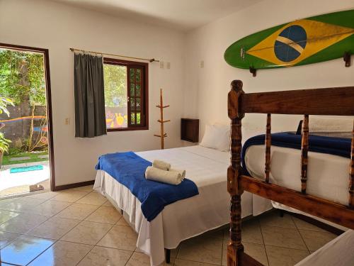 a bedroom with a bed and a surfboard on the wall at Raio de Sol pousada & camping in Abraão