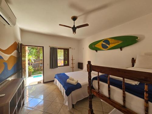 a bedroom with a bed and a surfboard on the wall at Raio de Sol pousada & camping in Abraão