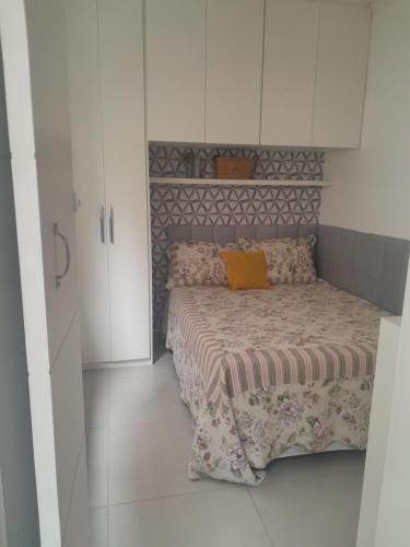 a small bedroom with a bed and white cabinets at Beira-mar in Santos