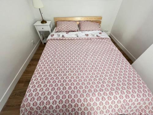 - une chambre avec un lit et une couette rose dans l'établissement Le petit Rochambeau, à Vendôme