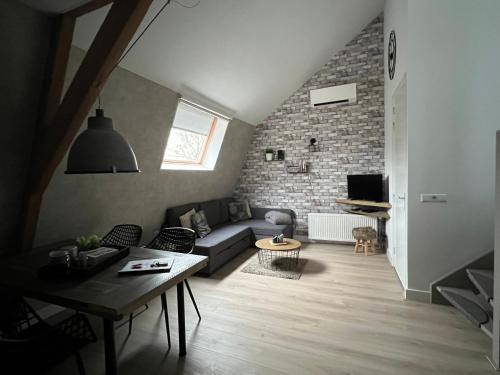 a living room with a couch and a brick wall at Gastenverblijf Rodenburg in Streefkerk