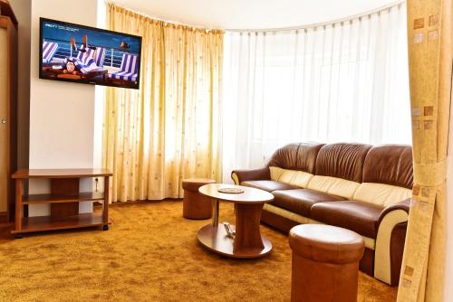 a living room with a couch and a tv at Hotel Oasis in Braşov