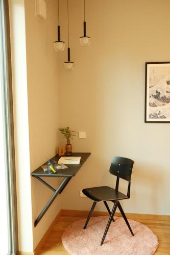 a black desk and a chair in a room at bluestar apartments am Storkower See inkl Badesteg und Gartensauna in Hubertushöhe