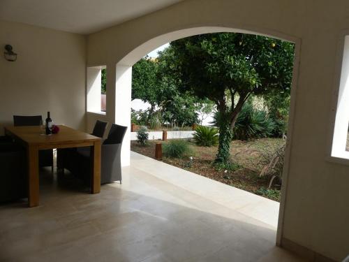 a dining room with an archway and a table and a tree at Villa Skoric in Orebić