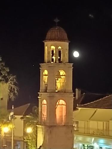 a building with a clock tower at night at Olympus View Rooms Sauna & Spa in Litochoro