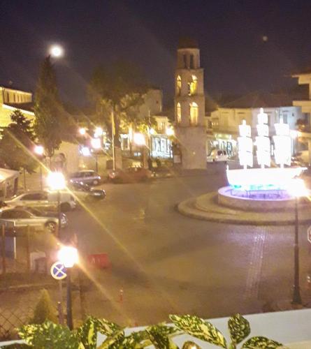 a city street at night with a clock tower at Olympus View Rooms Sauna & Spa in Litochoro