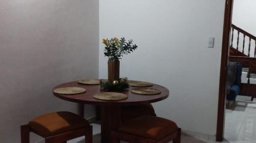 una mesa con sillas y un jarrón con flores. en Mammamia CasaHotel, en Duitama