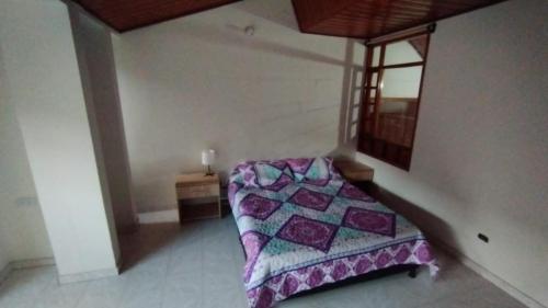 a bedroom with a bed in the corner of a room at Mammamia CasaHotel in Duitama