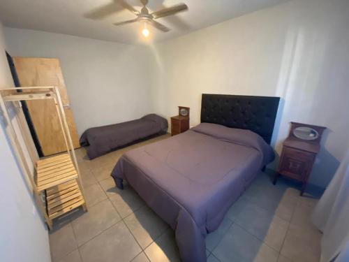 sypialnia z fioletowym łóżkiem i lustrem w obiekcie Aires Casas de campo w mieście Villa Santa Cruz del Lago
