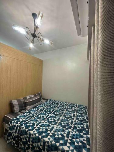um quarto com uma cama e uma ventoinha de tecto em CD Place staycation with Wifi & Netflix em Manila