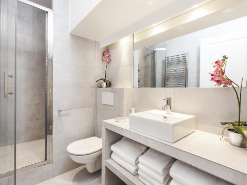 une salle de bain avec un lavabo, des toilettes et un miroir dans l'établissement LivinParis - Luxury 2 Bedrooms Grands-Boulevards I, à Paris