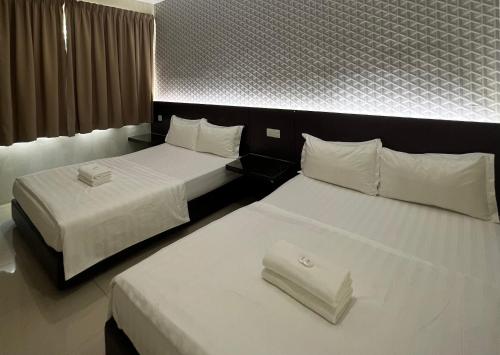 a hotel room with two beds with white sheets at Pekan Auto City Budget Hotel in Pekan