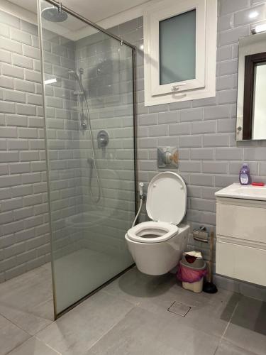 uma casa de banho com um WC e uma cabina de duche em vidro. em Hawana salalah luxury studio em Wādī Khasbar