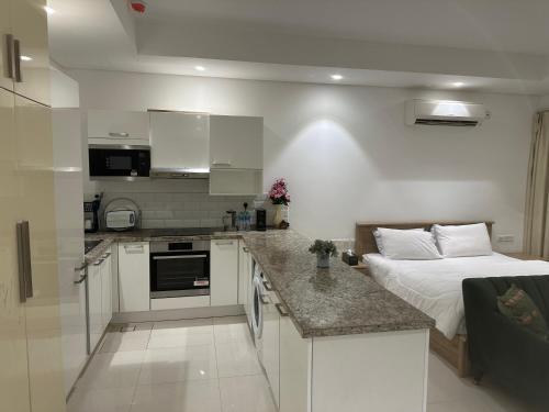um quarto com uma cama e uma cozinha com uma cama sidx sidx em Hawana salalah luxury studio em Wādī Khasbar