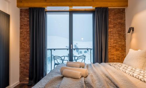 a bedroom with a bed and a large window at Gudauri Mountain Views in Gudauri