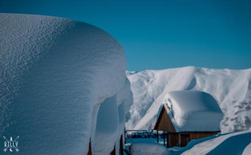 a building covered in snow next to a mountain at Gudauri Mountain Views in Gudauri