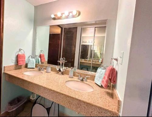 a bathroom with two sinks and a large mirror at Costa Bonita Apt in Culebra
