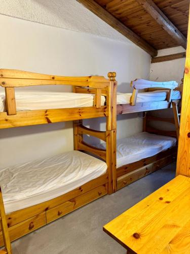 a room with three bunk beds in a cabin at Appartamento Marelè - Folgarida sky area Campiglio in Folgarida