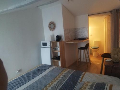 une chambre avec un lit et une petite cuisine dans l'établissement Studio au coeur de la ferme, à Saint-Lumine-de-Coutais