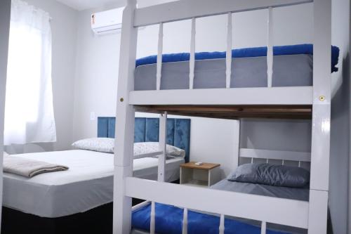 a bedroom with two bunk beds and a window at Cobertura Enseada de Zimbros in Bombinhas