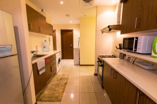 a kitchen with a stove and a microwave at Amazing Rooms for Men Guests for rent in Dubai Marina in Dubai