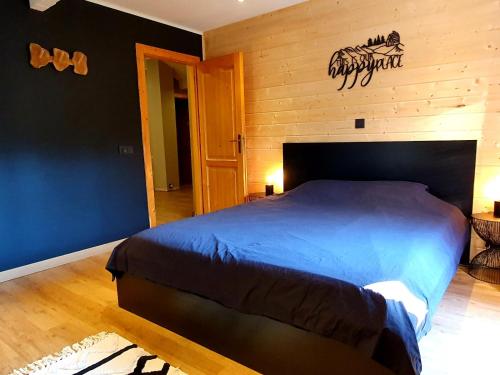 ein Schlafzimmer mit einem Bett und einer Holzwand in der Unterkunft Chalet Mésange in Érezée