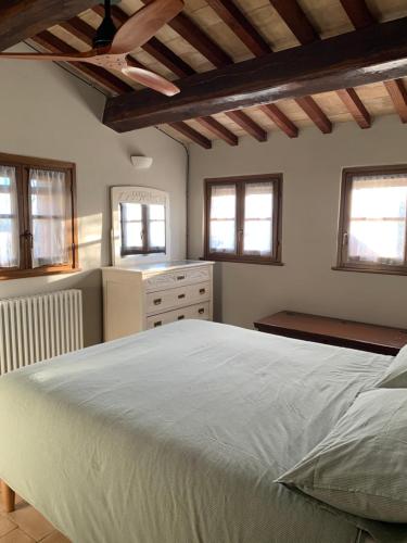 a bedroom with a large white bed and windows at Vesper - Casale con piscina - Ad Galli Cantum in Città della Pieve