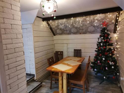 un árbol de Navidad en una habitación con mesa y sillas en Zaviy, en Yaremche