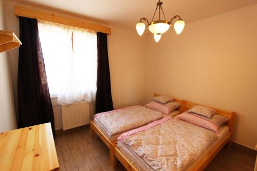 a bedroom with two beds and a window at Gesztenyés Vendégház in Garáb