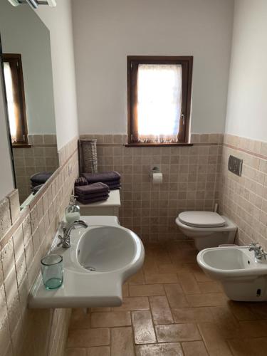 bagno con 2 lavandini, servizi igienici e finestra di Vesper - Casale con piscina - Ad Galli Cantum a Città della Pieve
