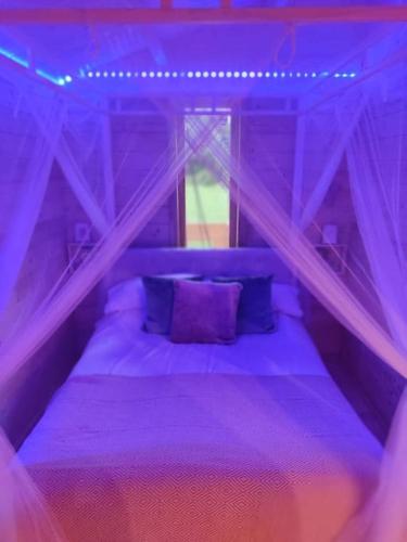 a purple bedroom with a bed with purple pillows at Luxury log cabin with wood fired hot tub in Moville