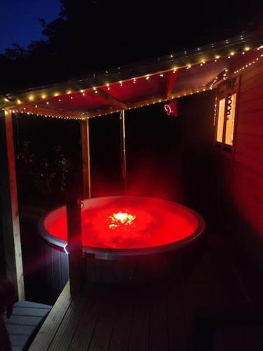 a red tub with lights on a deck at night at Luxury log cabin with wood fired hot tub in Moville