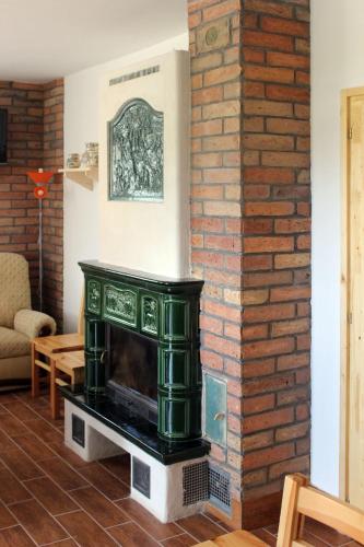 a fireplace in a living room with a brick wall at Gesztenyés Vendégház in Garáb