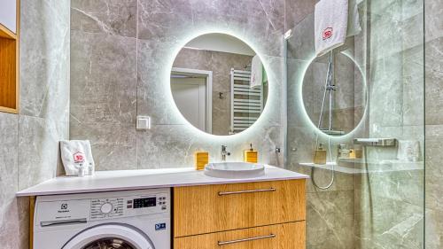 a bathroom with a washing machine and a mirror at Rezydencja Niechorze 115 - 5D Apartamenty in Niechorze