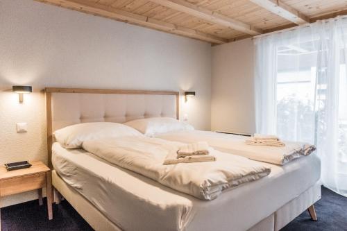- une chambre avec un grand lit et 2 serviettes dans l'établissement Chalet Eiger View - GRIWA RENT, à Grindelwald