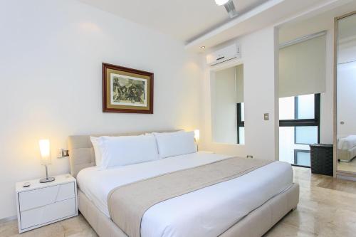 una camera bianca con un grande letto bianco di Menesse-2bedrooms-PerfectSpot steps to the ocean a Playa del Carmen