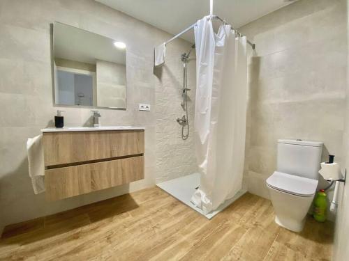 a bathroom with a toilet and a sink and a shower at Apartament Gritella ( Cim Apartaments ) in Cornudella