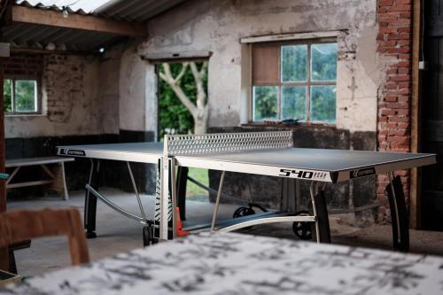 two ping pong tables in a room with windows at Glamping de Bosweide in Alphen
