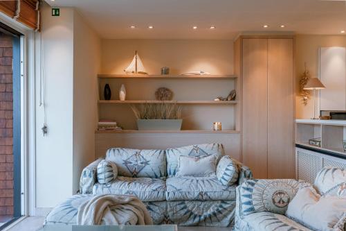 a living room with a couch and a chair at Premium Holidays - Stylish appartement Villa Castelli with C-View at Nieuwpoort! in Oostduinkerke