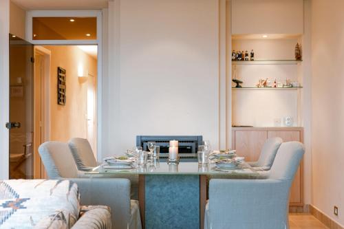 a dining room with a table and blue chairs at Premium Holidays - Stylish appartement Villa Castelli with C-View at Nieuwpoort! in Oostduinkerke
