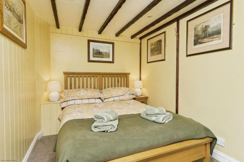 a bedroom with a bed with two towels on it at Lavender Cottage in Arreton