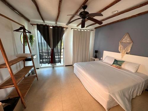 1 dormitorio con 1 cama y ventilador de techo en Hotel Arenas Mahahual en Mahahual