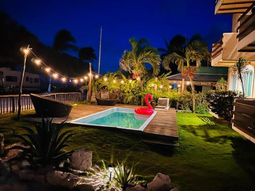 un patio trasero con piscina profunda y terraza de madera en Hotel Arenas Mahahual en Mahahual