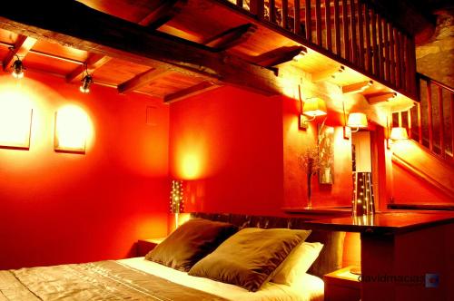 a bedroom with red walls and a bed with lights at Almazara de San Pedro in Eljas