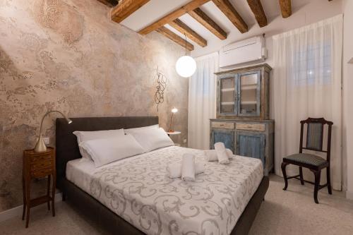 a bedroom with a large bed and a chair at "Ea casa de mì 2", l'incanto di vivere Venezia in Venice