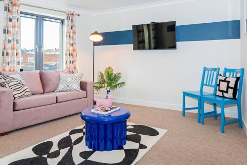 a living room with a couch and a table at Coastal Comfort Getaway in Portsmouth